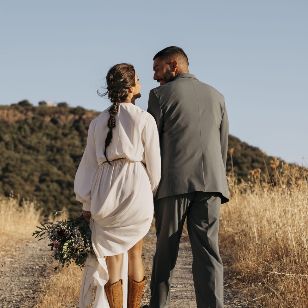 back-view-married-couple-holding-hands Coloured Couple walking along a path outside at their wedding after completing their Pre Marital Counselling Program