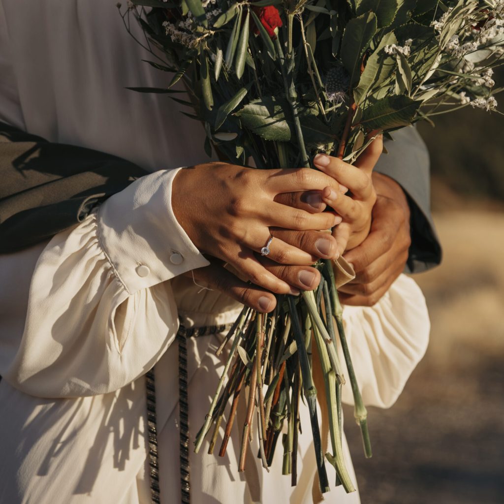 side-view-couple-holding-flowers-bouquet Coloured Couple standing with flowers at their wedding after completing their Pre Marital Counselling Program.