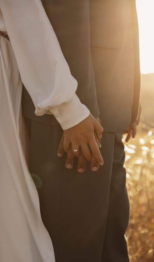 side-view-married-couple-holding-hands Couples standing holding hands, after getting married and after completing Pre Marital Counselling.
