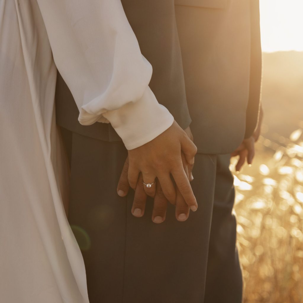 side-view-married-couple-holding-hands Couples standing holding hands, after getting married and after completing Pre Marital Counselling.