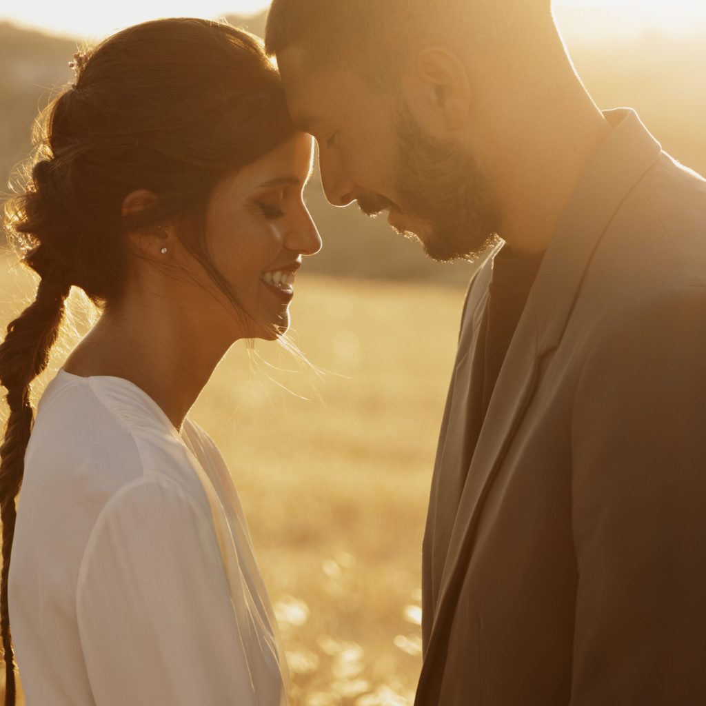 side-view-smiley-couple-posing-together Coloured Couple standing with their heads together at their wedding after completing their Pre Marital Counselling Program.